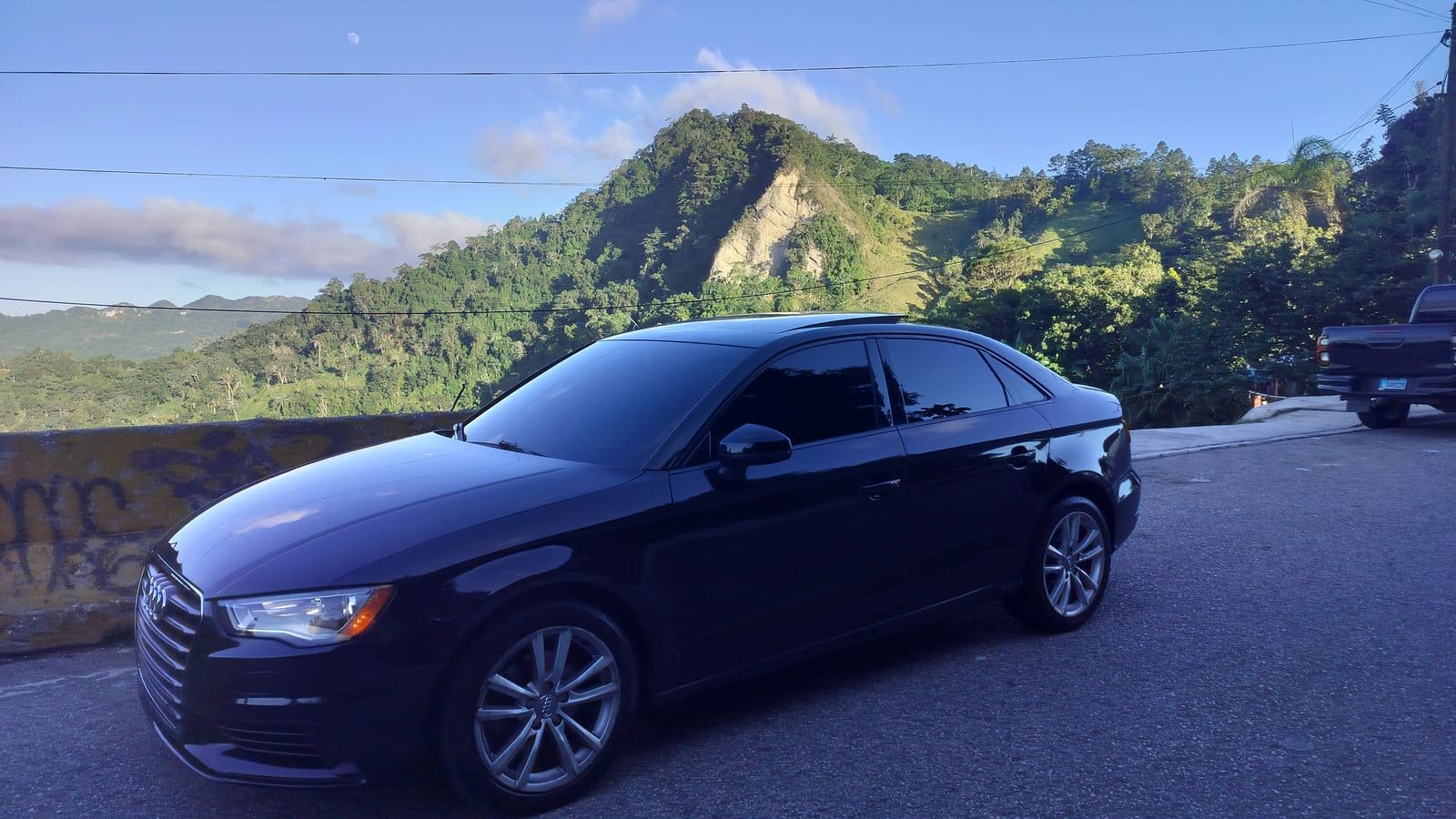 El Audi A3 negro de Grupo Fullequipe aparcado ante las montañas del interior de República Dominicana